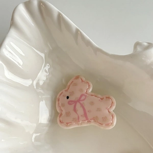 Close-up of pink resin rabbit hair clip with floral patterns and a cute bow detail