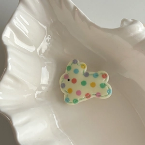 Cute bunny hair clip with colorful polka dots on a white shell decorative tray