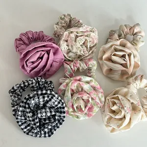 Flat lay view of rose-shaped hair scrunchies in various floral and striped fabric patterns