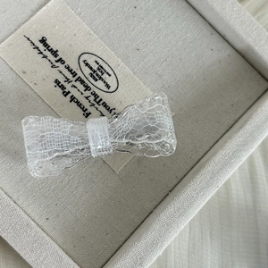 Elegant vintage acrylic hair clip with white lace pattern and a butterfly bow design