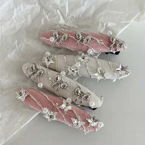Lot de barrettes à cheveux avec nœuds argentés, étoiles et perles sur fond blanc texturé