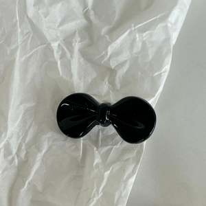 Fermaglio per capelli a fiocco nero per ragazze con finitura lucida su sfondo bianco