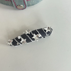 Vue détaillée de la pince à cheveux en résille noire avec strass étoiles et perles