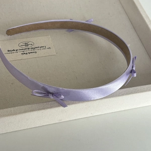 Elegant purple satin headband for girls featuring three small bows and a non-slip lining