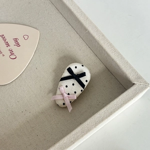 Haarklammer mit Polka-Dots und Bändern auf einem strukturierten Dekotablett