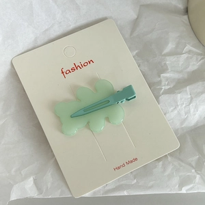Cute mint green acrylic bear hair clip on a white display card for stylish hair styling