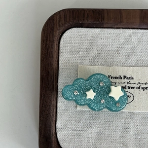 Cloud-shaped hair clip in blue glitter resin with white stars and rhinestones