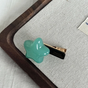 Star-shaped acetate hair clip in aqua green with metal duckbill clip for women