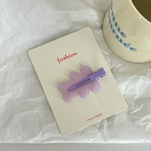 Detailed close-up of a purple resin bear hair clip with matching duckbill clip on white card