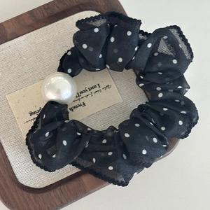 Black polka dot chiffon scrunchie with a large pearl bead on a natural linen card