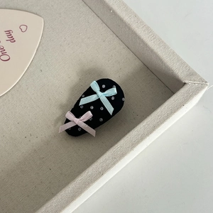 Detailansicht der gepunkteten Haarspange mit hellblauen und rosa Schleifen aus Stoff