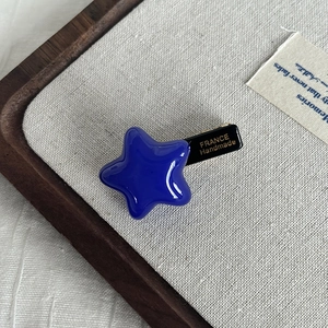 Detailed macro view of star hair clip featuring a France Handmade gold logo on the black clip