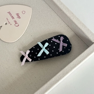Detailansicht der gepunkteten Haarspange mit drei bunten Seidenschleifen in einer Geschenkbox