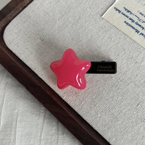 Detail of pink star hair clip showing France Handmade gold lettering on the black side clip