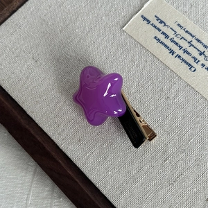 Macro view of purple star-shaped acetate hair clip with FRANCE Handmade engraving