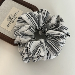 Detail shot of the black and white striped fabric texture on the vintage scrunchie