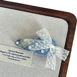 Vintage blue plaid hair clip with white lace bow and faux pearls on linen display
