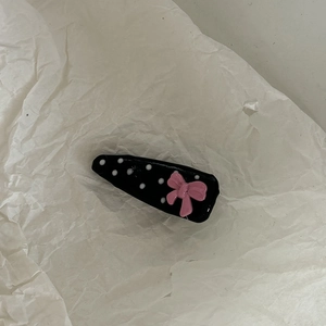 Detailed macro view of the glossy polka dot duckbill clip with a pink bow decoration