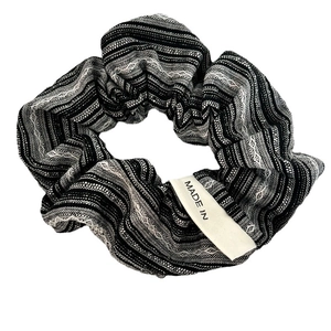 Classic black and white striped scrunchie in woven cotton with a small fabric brand tag