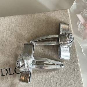 Close-up of metallic silver rose and bow hair clips with sturdy metal duckbill base