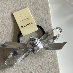 Elegant silver metallic bow hair tie with rose detail and black elastic band