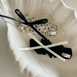 Detailed shot of handmade polka dot bow hair clips on a white shell-shaped tray