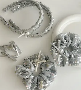 Close-up of silver sequin hair accessories set with pearl bows and handmade label