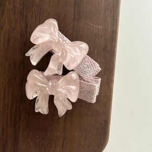Détail de barrettes à cheveux nœud rose translucide avec texture marbrée pour filles