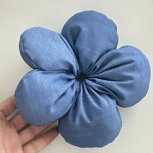 Nahaufnahme von hellblauem Jeans-Blumen-Haargummi mit detaillierten Blütenblättern