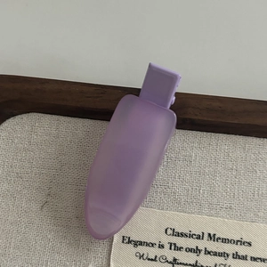 Macro detail of purple matte hair clip with smooth texture on elegant fabric background