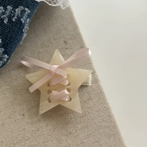 Pince à cheveux étoile crème avec rubans roses style ballet sur fond de lin rustique