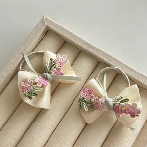 Set di fermacapelli a fiocco con ricami floreali rosa e lavanda su base di raso beige