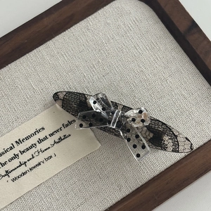 Close-up of lace pattern and polka dot bow detail on a stylish acrylic hair clip