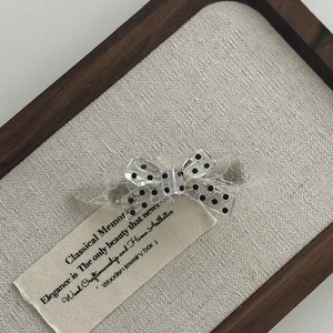 Detailed view of polka dot lace bow hair clip with silver metal duckbill clamp