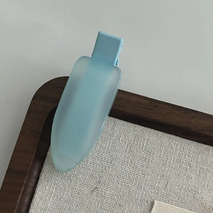 Detailed close-up of a matte light blue hair clip with a minimalist translucent design