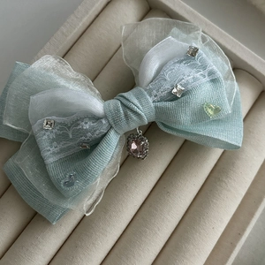 Barrette en résille bleue avec dentelle et pendentif en pierre rose sur plateau