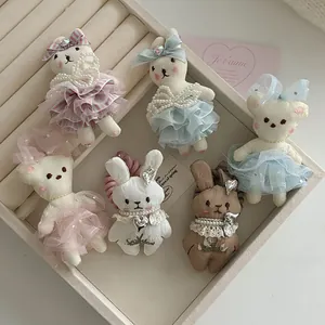 Close-up of cute plush bunny and bear hair accessories with lace ballet skirts and pearls