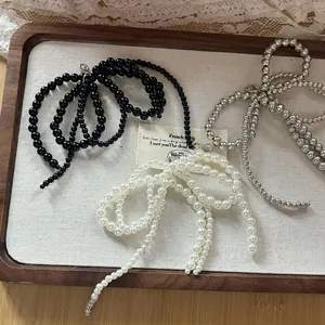 Vue détaillée de breloques en perles et argent avec fermoirs homard sur lin vintage