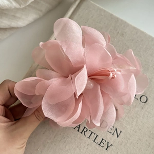 Close-up detail of layered pink mesh flower hair claw with elegant pearl center