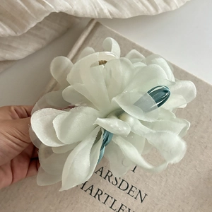 Close-up of large mesh pearl flower hair claw clip with delicate layered tulle petals