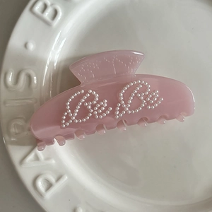 Pink translucent acetate shark clip with Bebe pearl lettering in a sweet ballet style