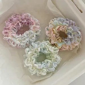 Tre elastici per capelli pastello in rosa viola e verde con consistenza soffice