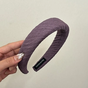 Détail du serre-tête éponge violet à texture ondulée avec étiquette fait main