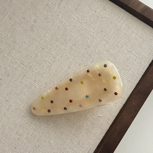 Creamy translucent hair clip with colorful rhinestones in a retro triangle design