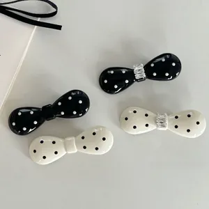 Vue détaillée de pinces à cheveux à pois avec cristal sur fond gris texturé