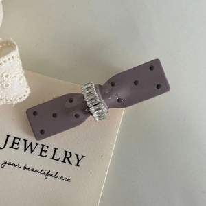 Elegant polka dot bow hair clip in purple-grey with crystal embellishment