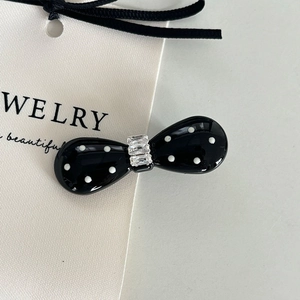 Pince à cheveux nœud noir à pois avec accents de cristal sur carte à bijoux