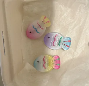 Close-up of three jelly-colored gradient fish hair clips in cute translucent resin