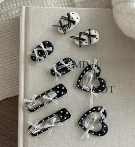 Gros plan de barrettes à pois avec nœuds en ruban de soie sur un livre vintage