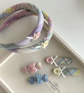 Detailed set of plaid fabric headbands and bow hair clips in pastel purple and pink colors